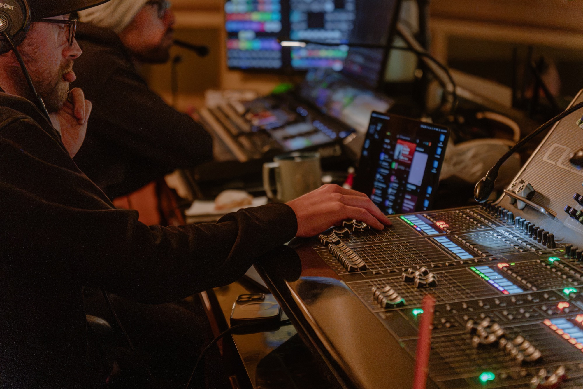 A production technician wearing a headset at an audio mixing desk during Main Street Maryland